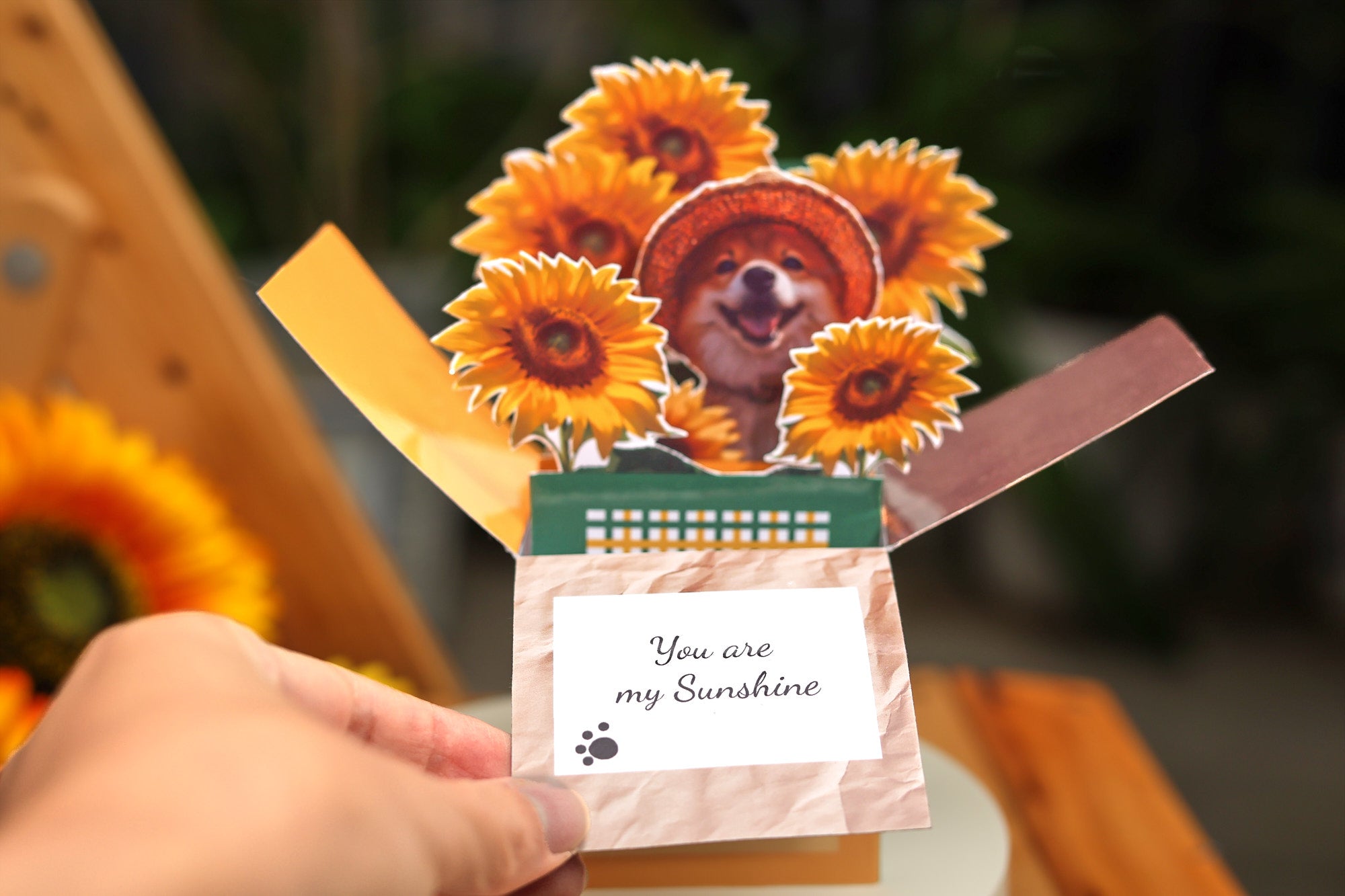 Open 3D pop up card with a happy dog and sunflower bouquet popping out of a gift box, layered paper design with vivid depth and playful summer theme